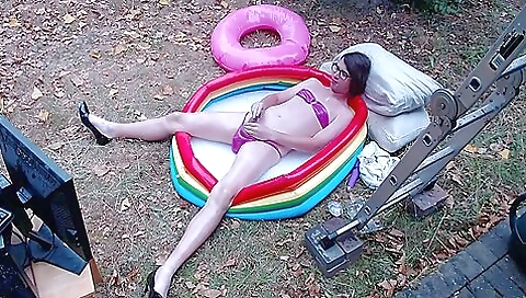 Outdoor teen is drenched in a pink pvc micro bikini